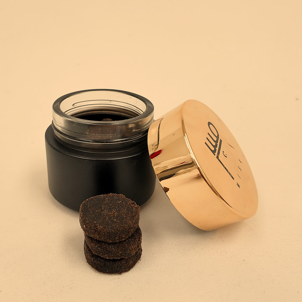Tafas handmade bakhoor — three pieces stacked beside the jar
